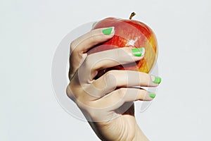 Red apple in hand with manicure. female hands. beauty salon woman shellac polish