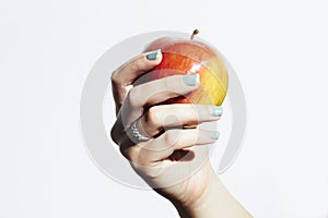 Red apple in hand with manicure.female hands.beauty salon woman shellac polish photo