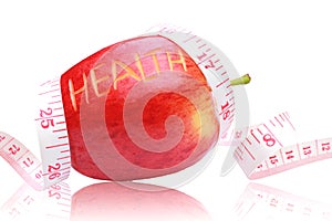 Red apple ,health text and measuring tape wrapped around.