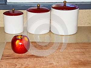 Red apple on kitchen counter breadboard