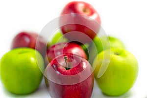 Red apple among lots of green and red apples isolated white ba