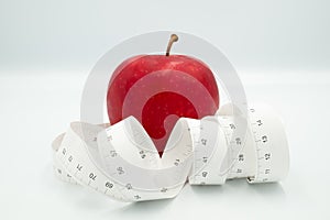 Red apple and measure tape centimeter that represent reduce weight or diet food and exercise for body good shape design concept