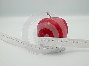 Red apple and measure tape centimeter that represent reduce weight or diet food and exercise for body good shape design concept