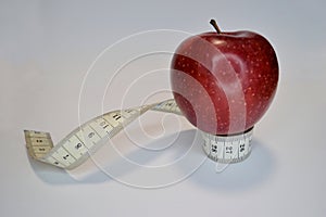 Red apple with measure tape on white background