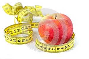 Red apple with measure tape on white background, healthy diet