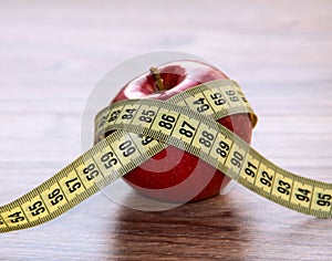 A red Apple is measured by a meter. Slimness and diet