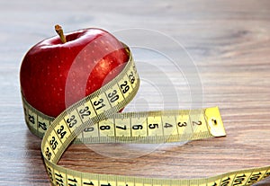 A red Apple is measured by a meter. Slimness and diet