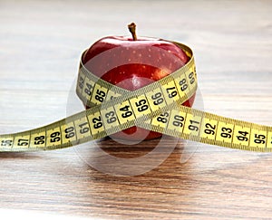 A red Apple is measured by a meter. Slimness and diet