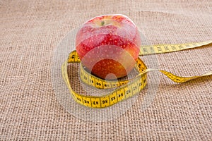 Red apple with a measurement  tape on it