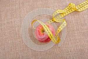 Red apple with a measurement tape on it