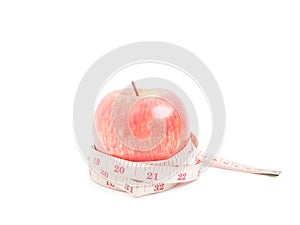 Red apple with measuring tape on isolated object on white background - diet concept
