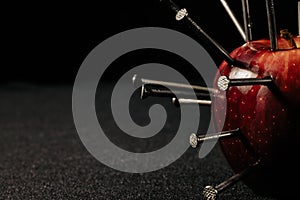 a red apple and nails