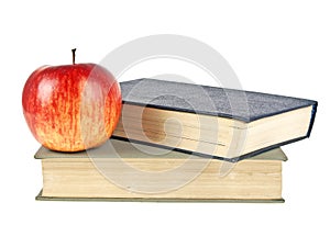 Red apple and old books isolated on white background