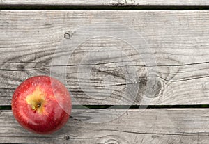 Red apple on old wooden table from above