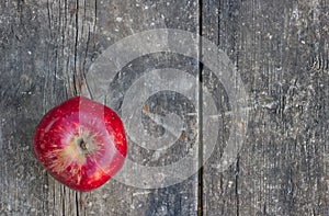 red apple on an old, worn garden table