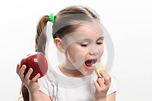 Red apple and potato chips, healthy and unhealthy food for children, little girl makes a choice between healthy and