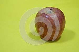 A solo gala apple on yellow background photo