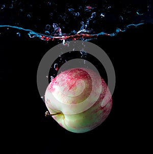 Red apple spash in water on black