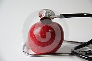 Red apple, with stethoscope, on white background