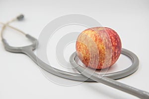 Red apple and stethoscope on white background