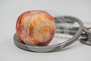 Red apple and stethoscope on white background