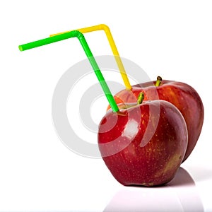 Red apple with a straw for a cocktail on a white background.