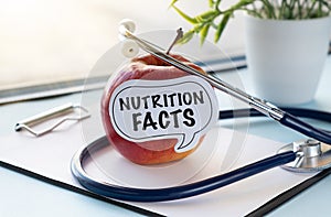 Red apple with text Nutrition Facts and measuring tape on background