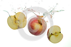 Red Apple and and two aple slices splash in water on white background