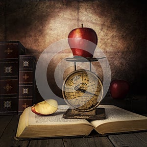 Red Apple with vintage small scale  on top of open book