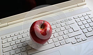 Red apple on a white computer keyboard with latin characters only stock photo