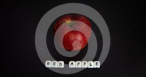 Red apple with white writing on dark background photo