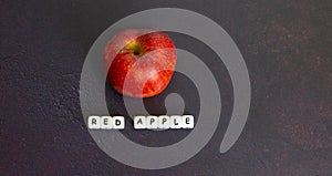 Red apple with white writing on dark background photo