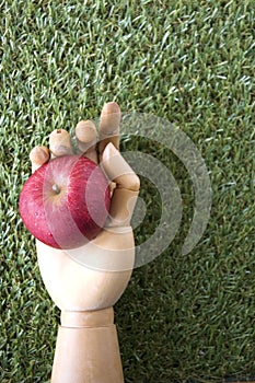 Red apple in wooden hand