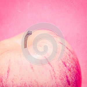 Red apple on a worn pink background