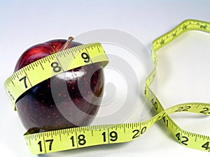 Red apple and yellow tape measure