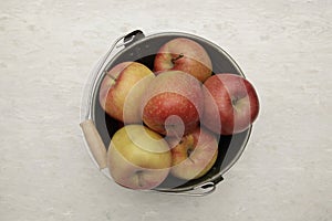 Juicy red apples in an old bucket with a handle