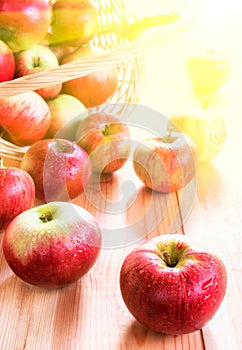 Red apples in basket on wooden table background. Fresh autumn harvest. Rustic style. Selective focus