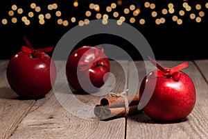 Red apples and cinnamon sticks on the background of Christmas lights, apple pie recipe