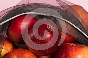 Red apples in a fruit and vegetable grid close-up. Concept of earth day, zero waste and recycling