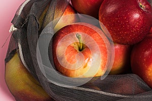 Red apples in a fruit and vegetable grid close-up. Concept of earth day, zero waste and recycling