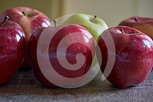 Red apples and a green one