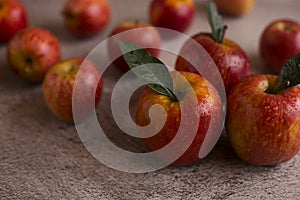 Red apples with leaves on a gray background