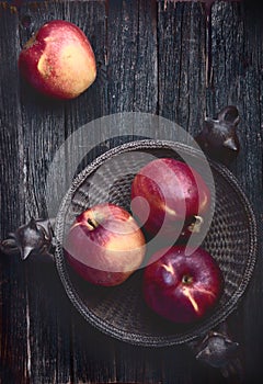 Red apples on old dark rustic wooden table surface, flatlay