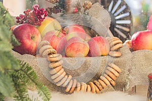 Red apples and round-shaped cracknel on rope behind the glass photo