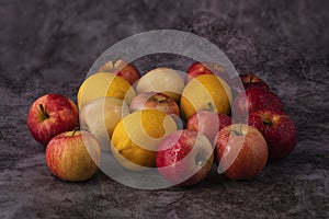 Red apples are scattered on the gray marble table