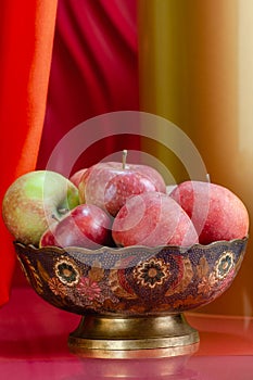 Red apples in a vase in oriental style on a stylish background