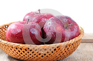 Red apples in wicker basket isolated