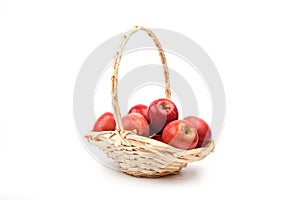 Red apples in wicker basket isolated on white .