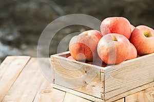 Red apples in wooden boxes on the table . Copy space