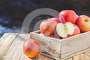 Red apples in wooden boxes on the table . Copy space